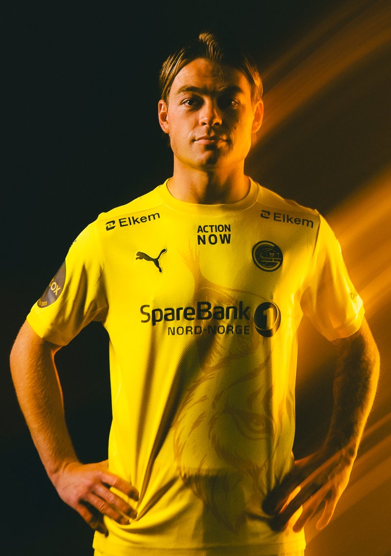 Patrick Berg poserer i Bodø/Glimts nye hjemmedrakt for sesongen 2024 med et gult lys fra høyre side i bildet