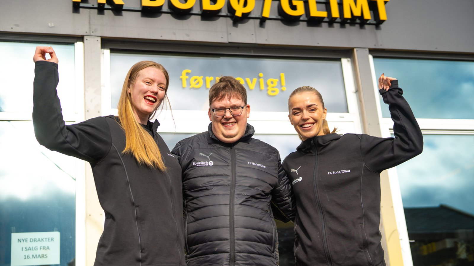 Aubrei Corder og Andrea Holmstrøm fra Bodø/Glimt Kvinner sammen med John-Håkon Nybak som jobber i Glimt-shop uten for Glimts supporterbutikk på Aspmyra stadion