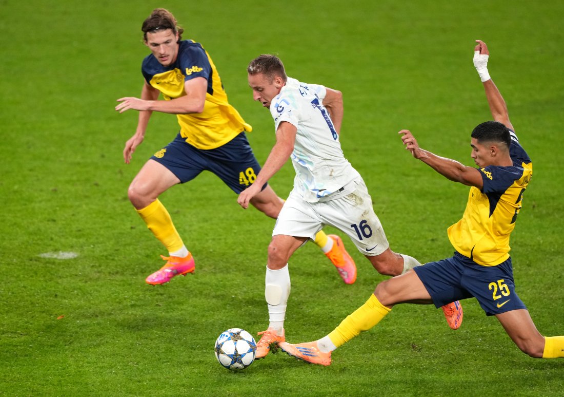Bildet viser en Inter-spiller med to Union-spillere rundt seg