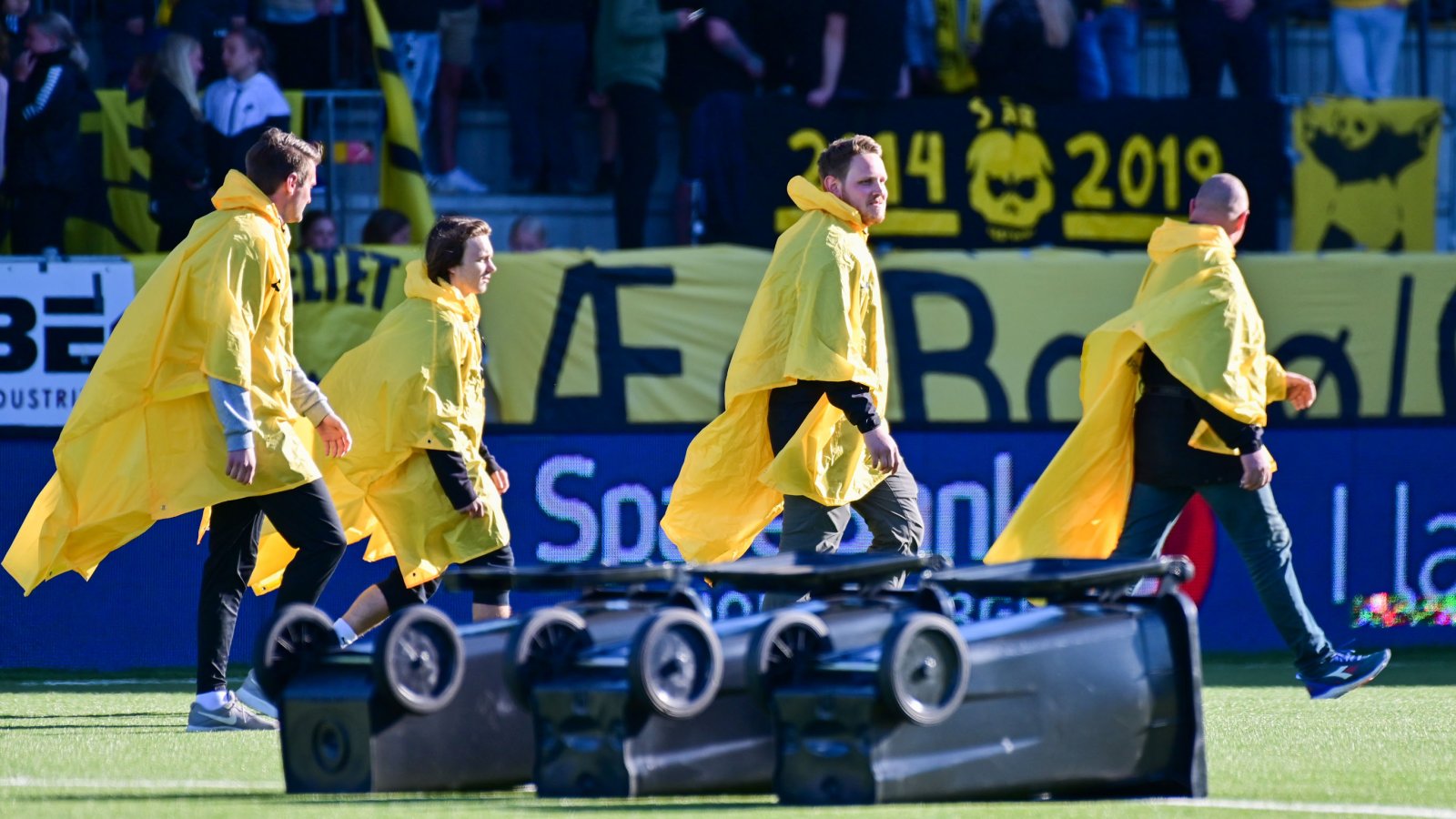 Deltakerne klare til fotballcurling, med en vri, i pausen under kampen mot Strømsgodset på Aspmyra. 