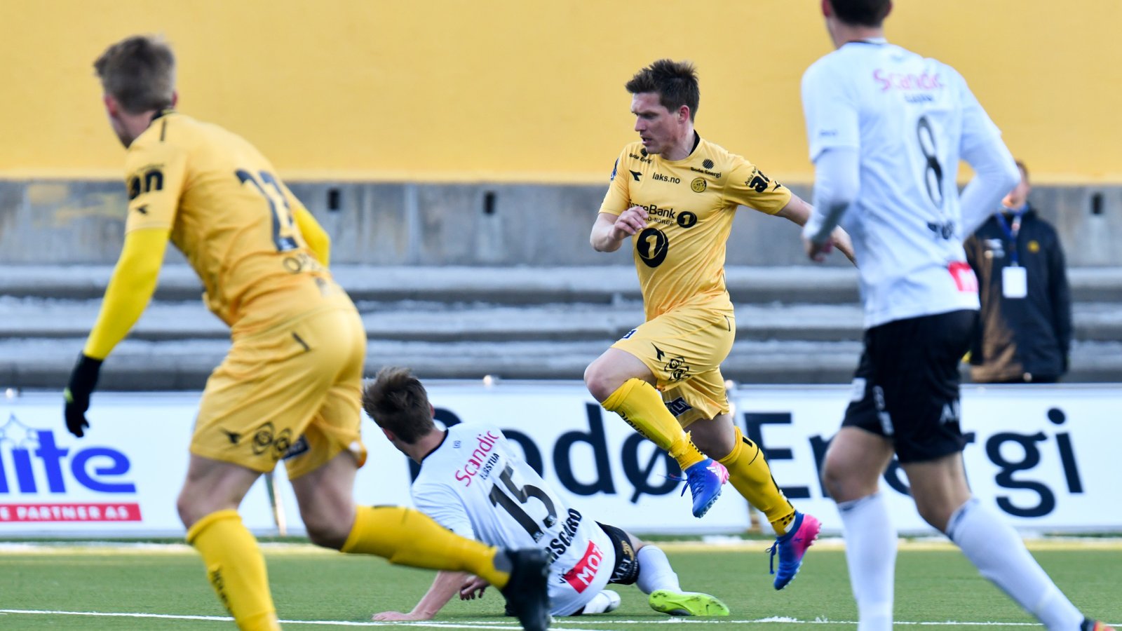 TETTE DUELLER: Thomas Jacobsen (5) blir taklet av Erlend Eggen Persgård (15) i vårens seriekamp mot Elverum. Oppgjøret endte til slutt 5-0 til Glimt.  I forgrunnen: Kristian Fardal Opseth (22) og Håkon Rønes (8). FOTO: Kent Even Grundstad