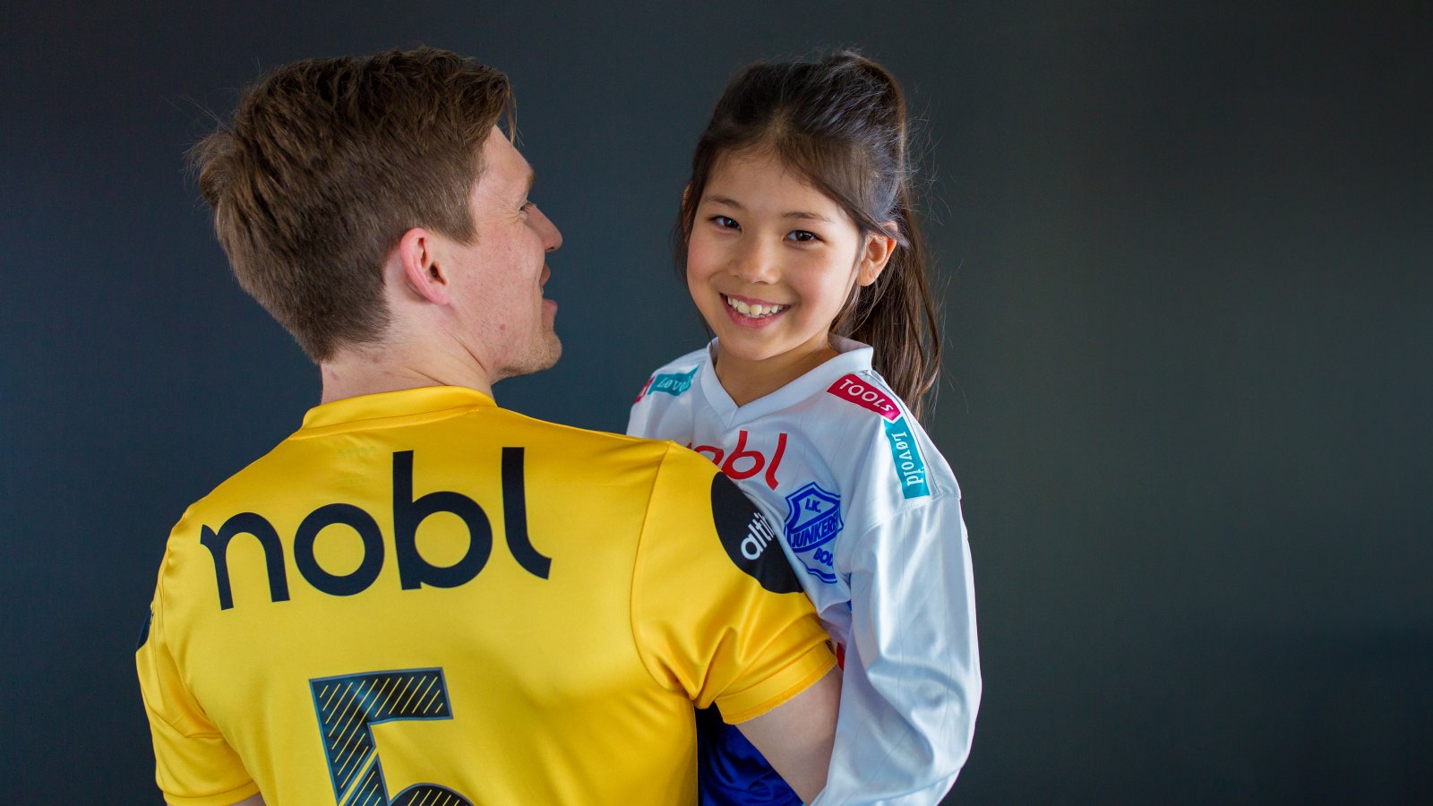 Nobl er stolt sponsor både i breddeklubben Junkeren og i Bodø/Glimt. A-lags-spiller Thomas Jacobsen, med Junkerenspiller Lisa Lewin på armen.