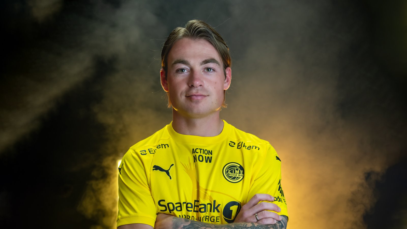 En glad Patrick Berg står inne i TV-studioet til Glimt og smiler etter at han har signert ny kontrakt med klubben.