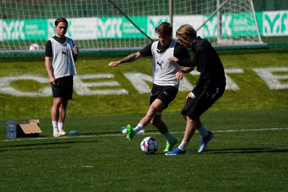 En løpende Sondre Sørli passes på av Jens Petter Hauge på treningsfeltet i spanske Marbella. Patrick Berg står i bakgrunnen og ser på.